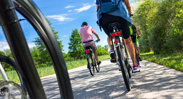 Eine Gruppen von Radlerinnen und Radlern bei einer Radtour im Sommer